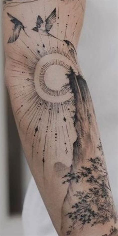 A Person Sitting In A Chair With A Tattoo On Their Arm That Has Birds